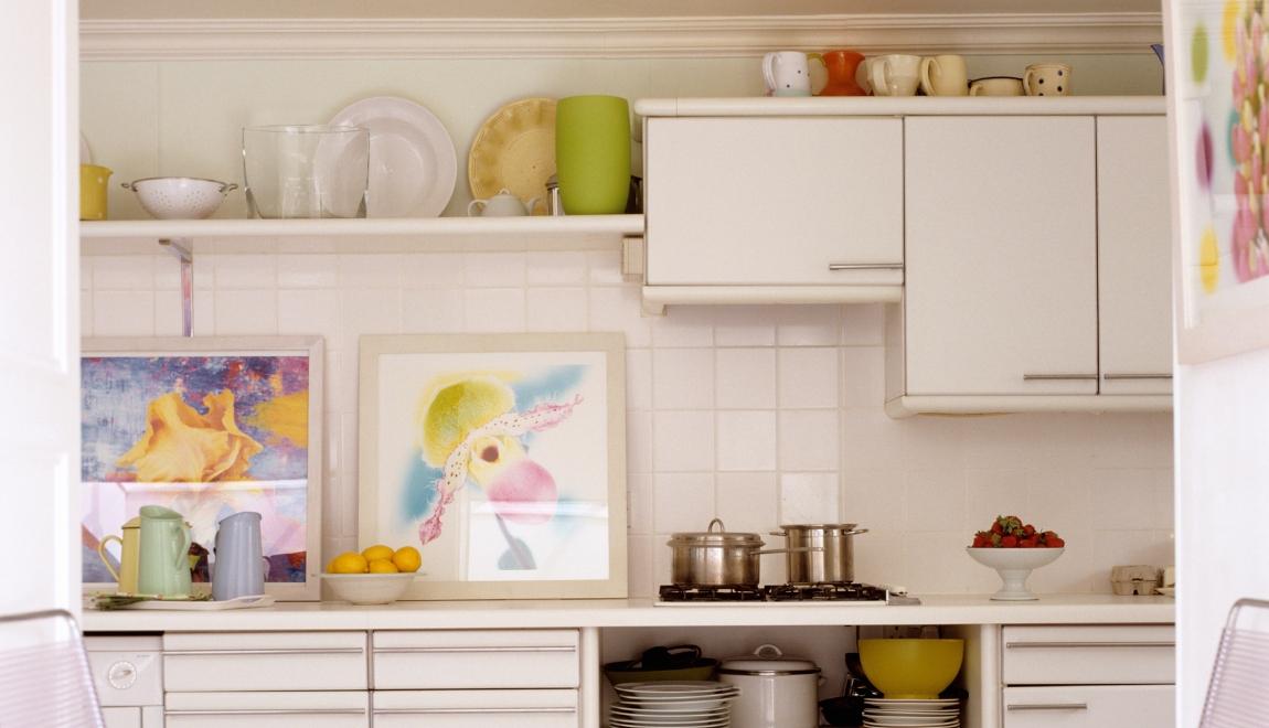 Artwork and decorative dinnerware displayed in the kitchen.