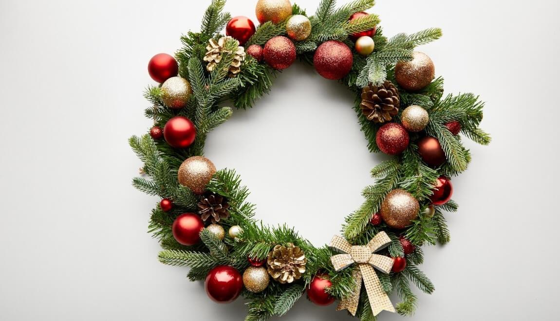 A Christmas wreath decorated with ornaments and bows.