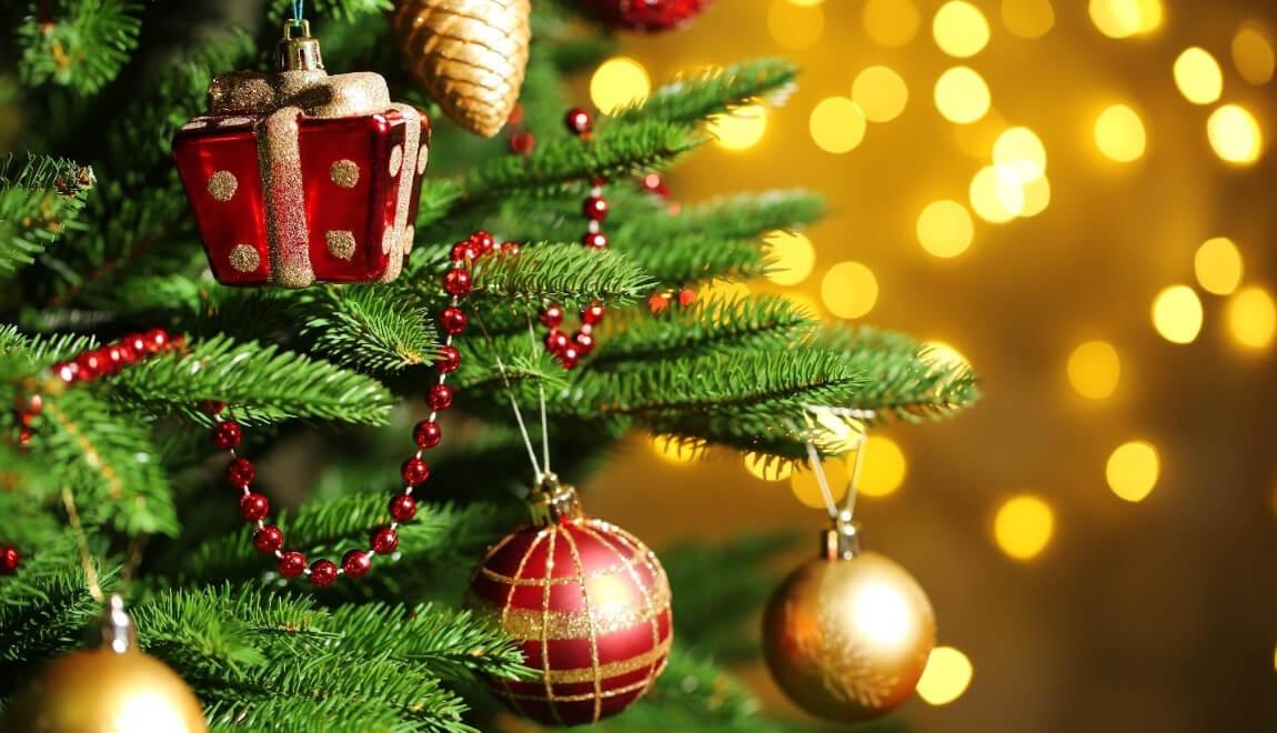 Close-up of branches of a Christmas tree decorated with ornaments.