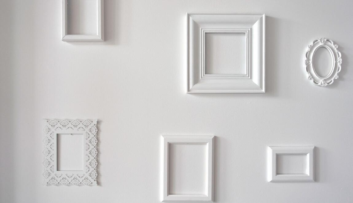 White picture frames against a white wall.