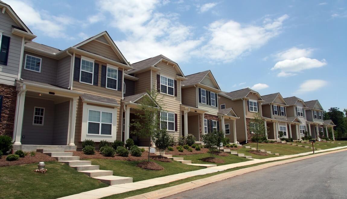 A row of townhomes line a street.