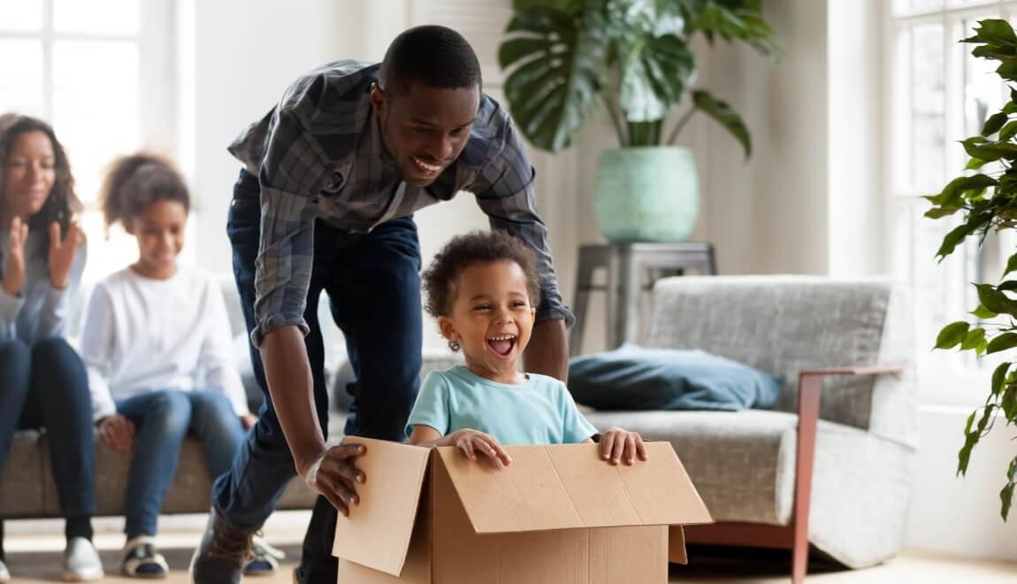 A father playing with his child in the living room