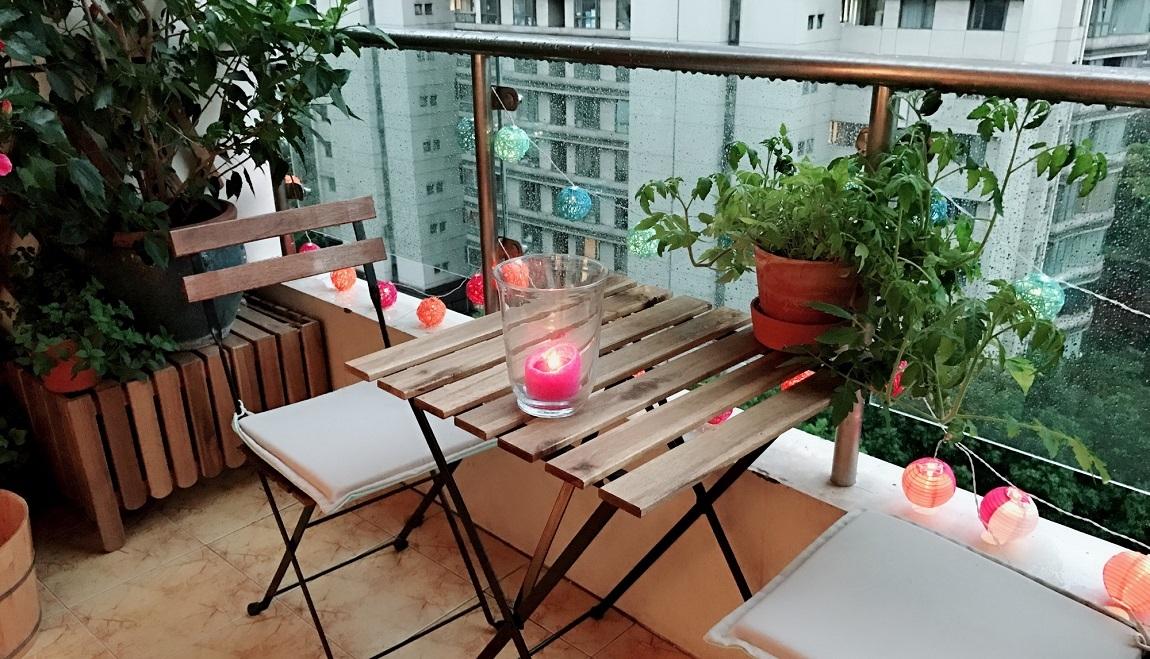 A small outdoor dining table with candles on top. 