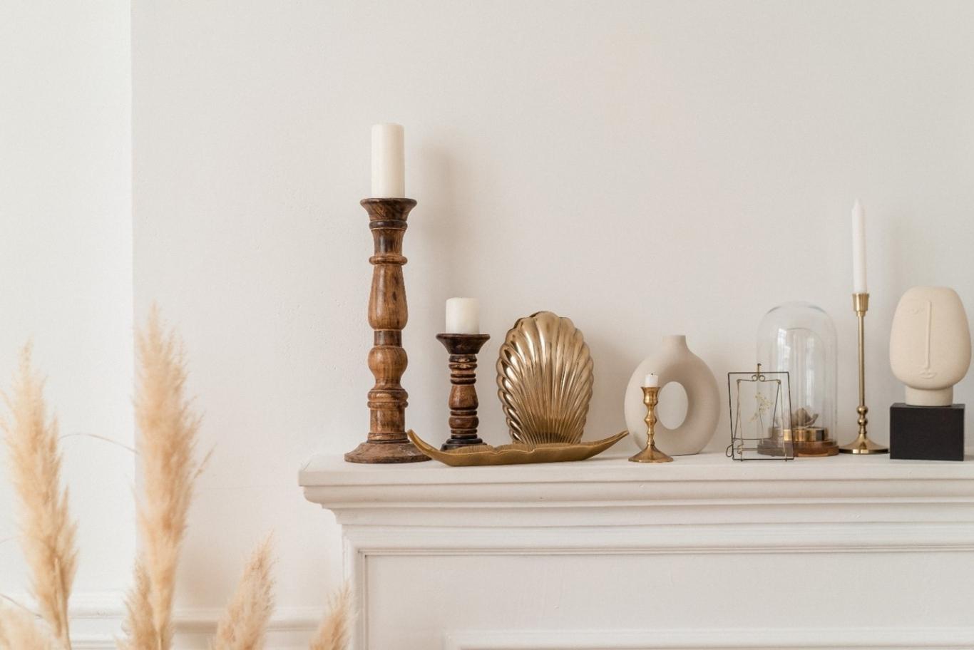 Antique candlesticks sit atop a white fireplace mantel.