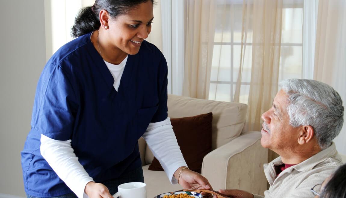 A nurse tends to a resident in an assisted living facility.