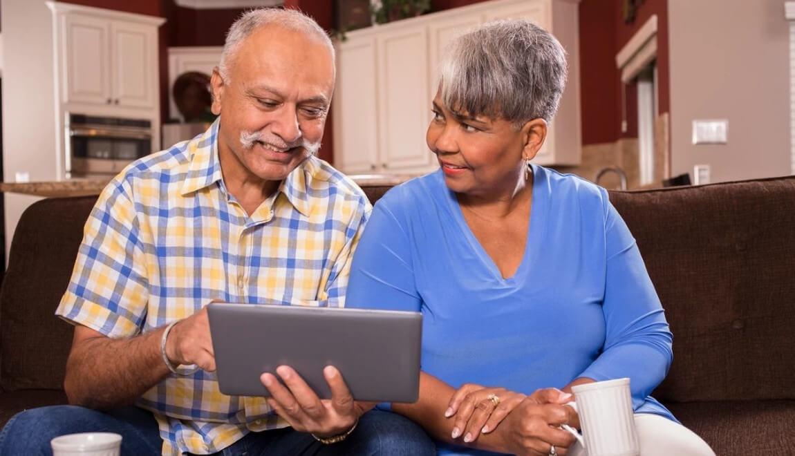 A senior couple view a tablet together. 