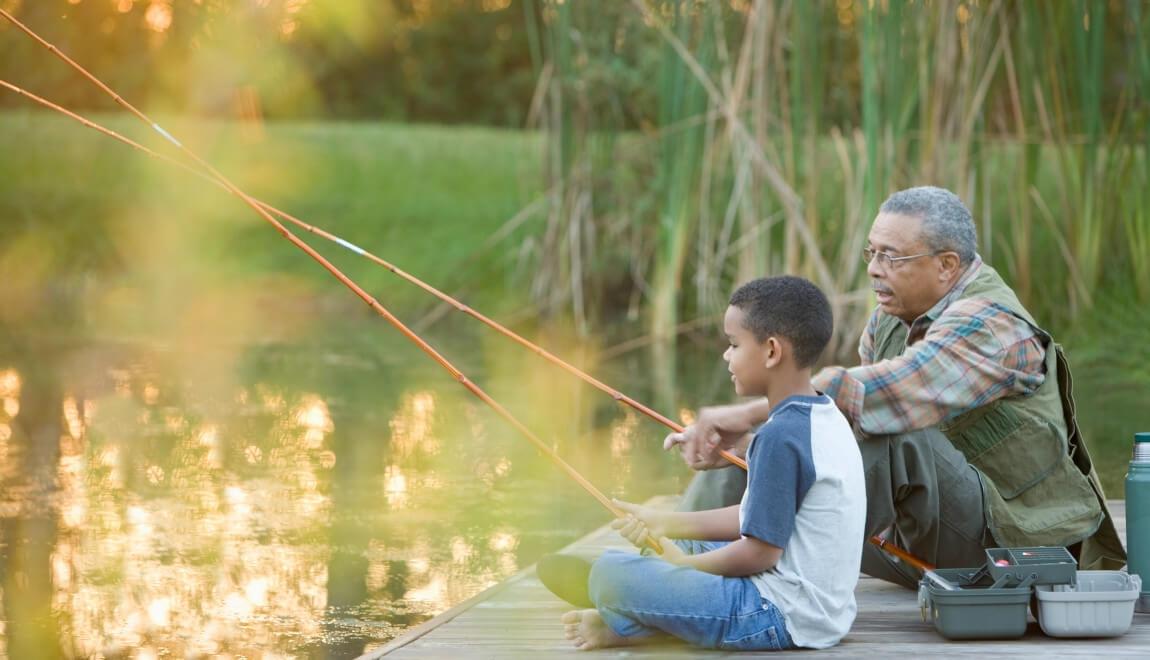 An older man and a child fishing off a dock.
