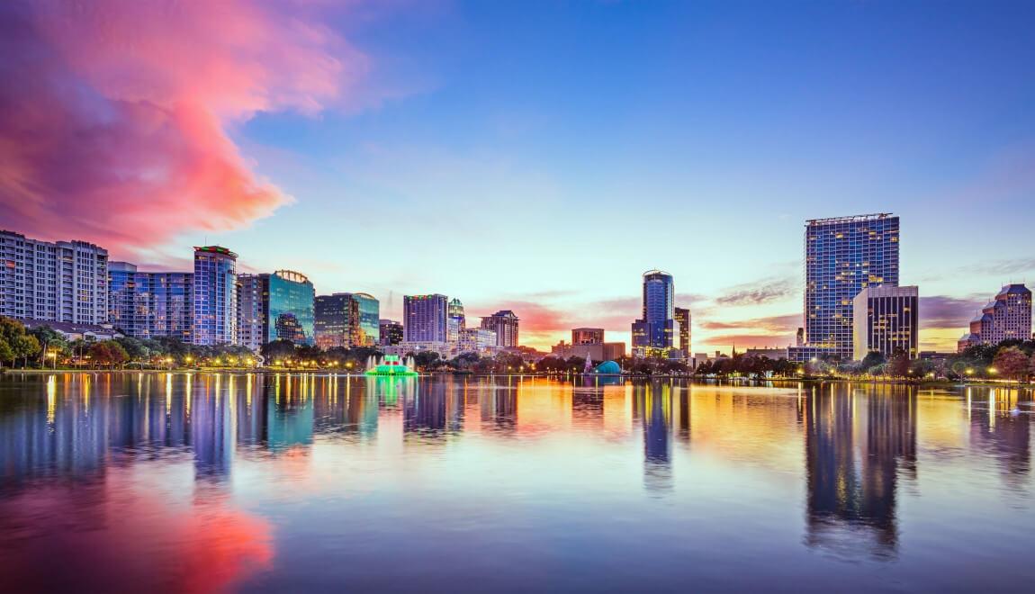 The Orlando skyline is reflected on the smooth surface of Lake Eola.