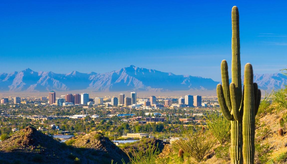 Mountains and desert frame the Phoenix, AZ skyline.