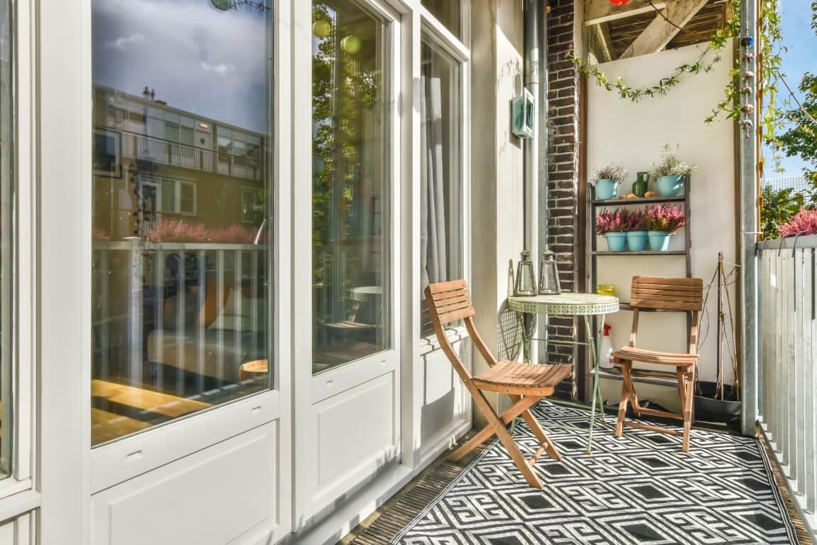 An image of a balcony with chairs and a table on a spring day. 