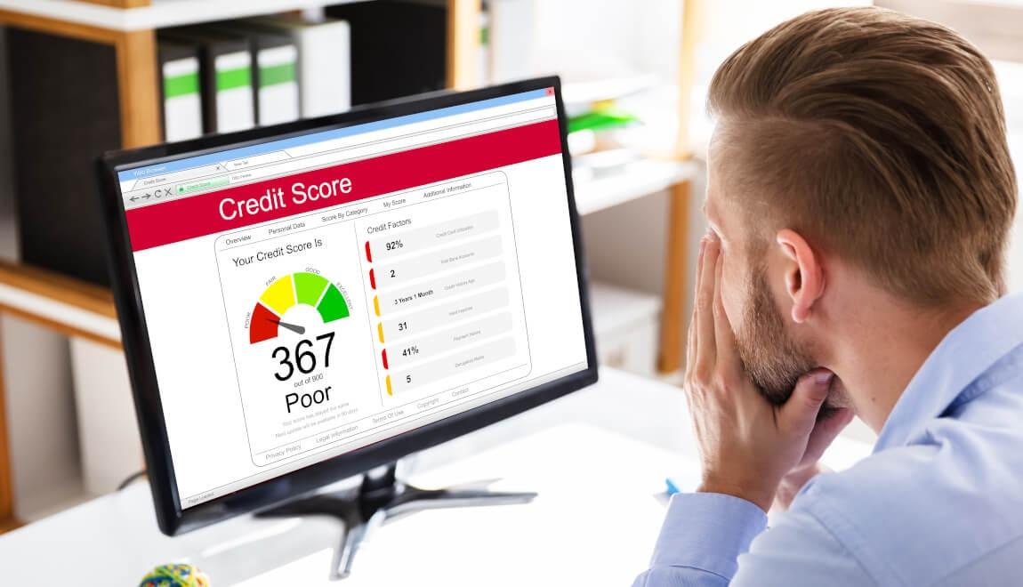 A distressed man looking at his poor credit score.