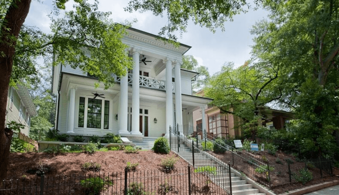 The front porch of 1013 Euclid Ave NE features two-story Roman columns and a balcony on the second level.