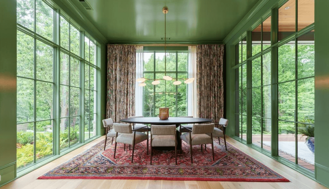 The dining area in 263 Blanton Rd NW features floor-to-ceiling windows that look out into the tree-lined backyard.