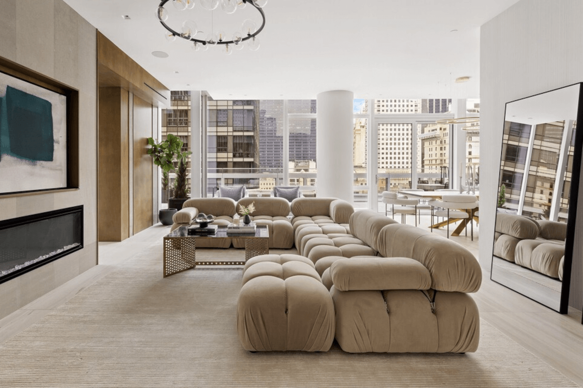 The modern living room at 20 West 53rd Street is lit by natural sunlight and contemporary light fixtures.