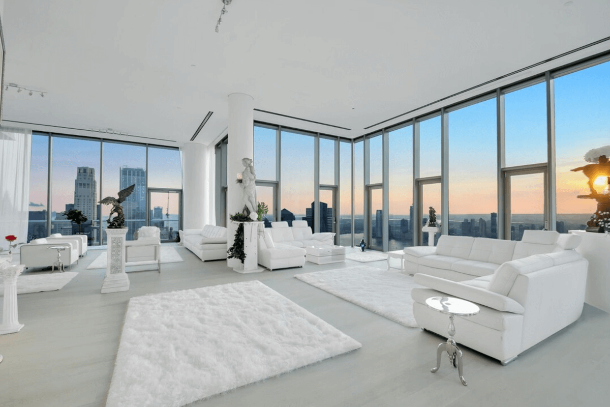 A view of New York City at sunset is shown from the living room at 56 Leonard Street.