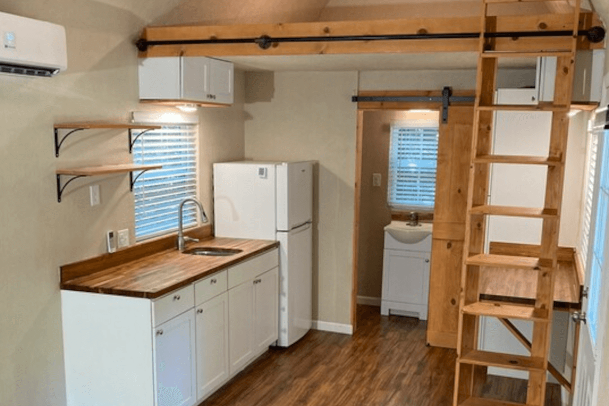 The kitchen has shelving and cabinet space despite its size.