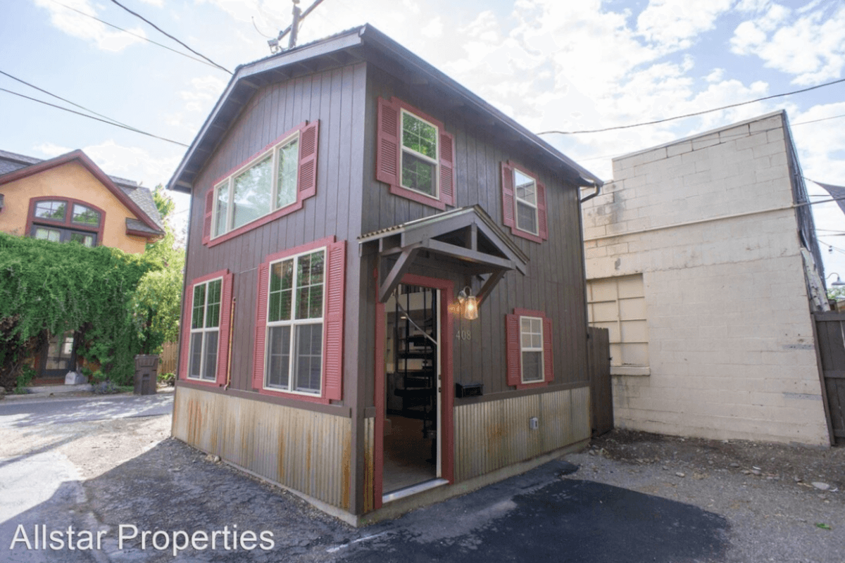 408 North Main Street is a small brown cottage with red window shutters.