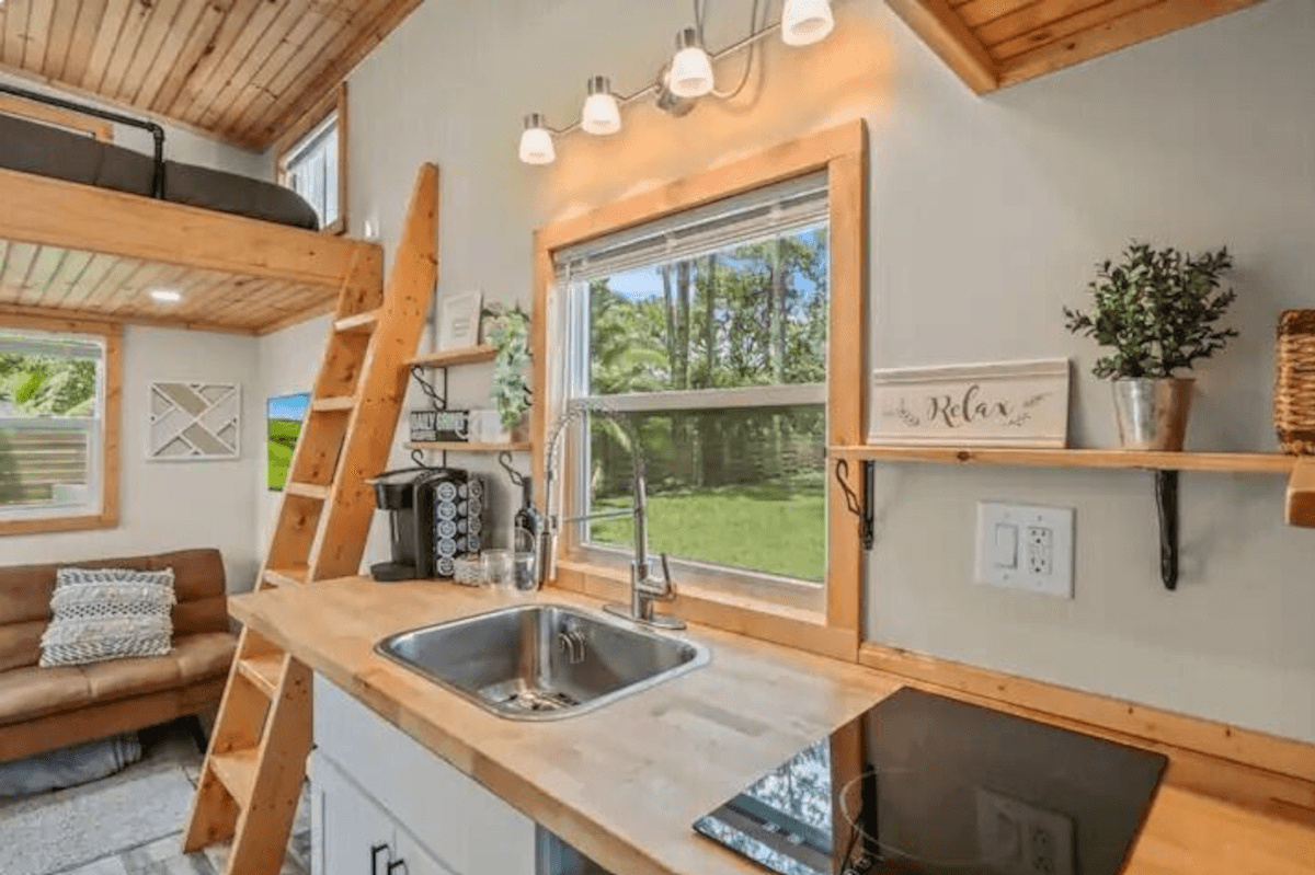 The kitchen area in 4871 127th Trail North has plenty of light, with a large window and four pendant lights above the sink.