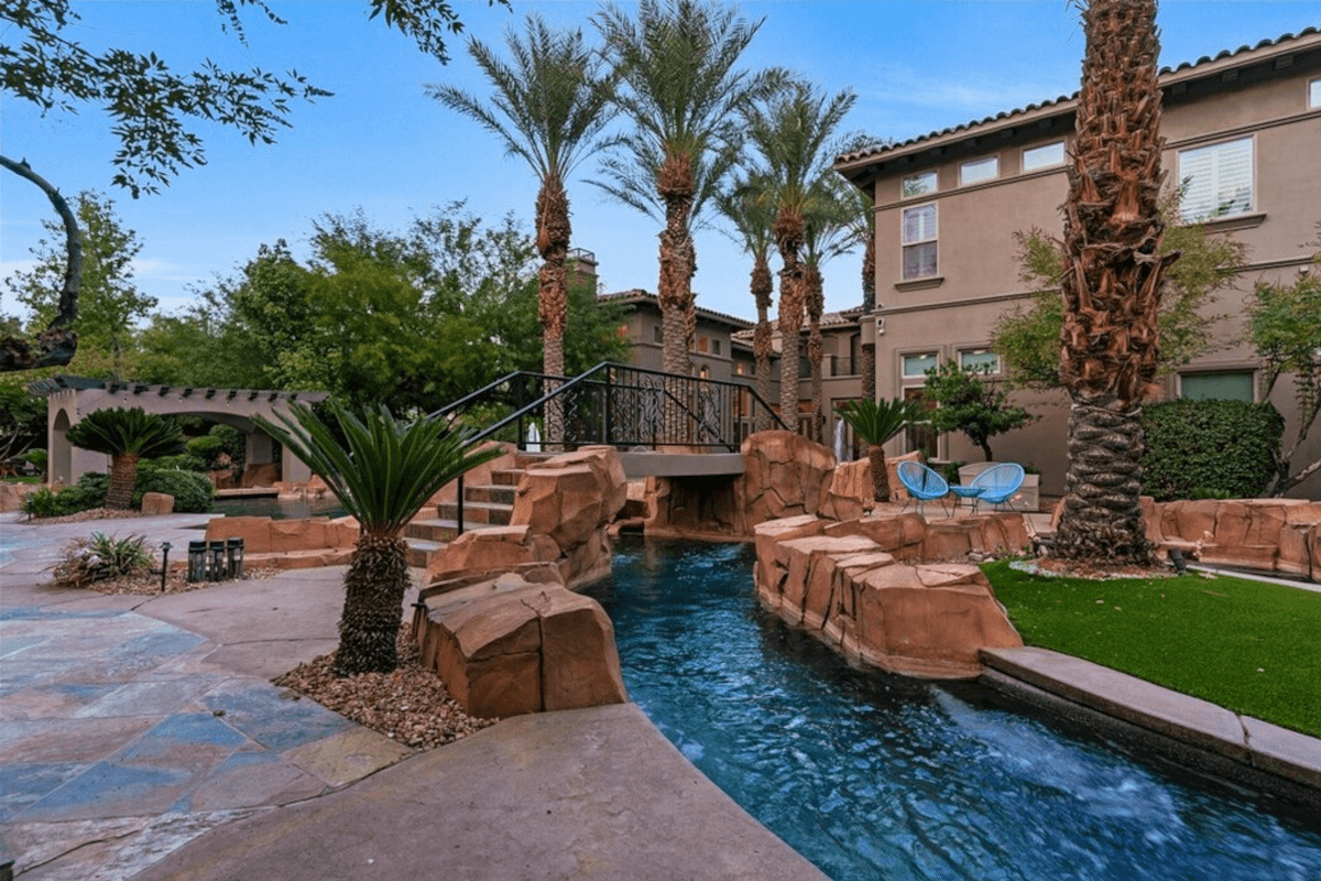 A bridge arches over the lazy river in the backyard of 5 Wood Creek Court.