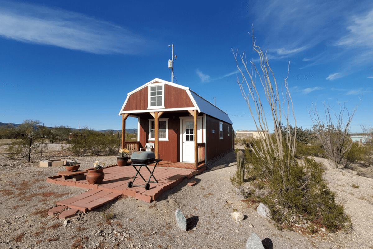 A red barndominium-style tiny home sits in the middle of the desert in Ajo, Arizona.