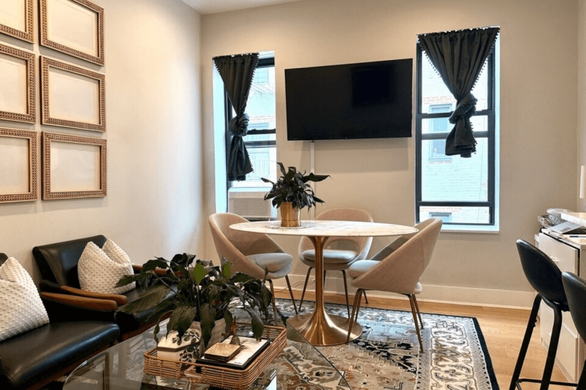 The dining area in 601 Crown Street has two small windows letting in natural sunlight on either side of the TV.
