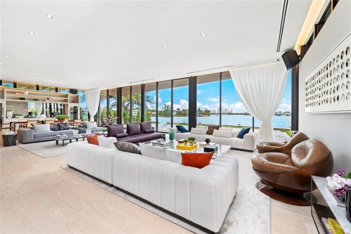The living room at 15 East San Marino Drive has cozy sofas and floor-to-ceiling windows.
