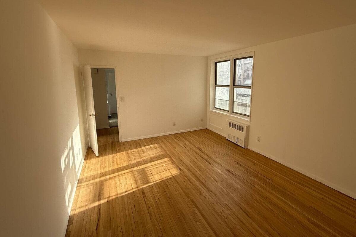 Golden hour lighting streams through a bedroom window at 3855 Orloff Ave.