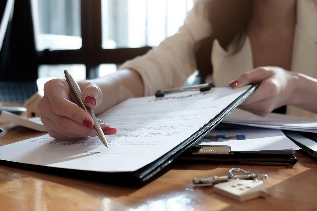 A property manager points at the signature line on a lease agreement.