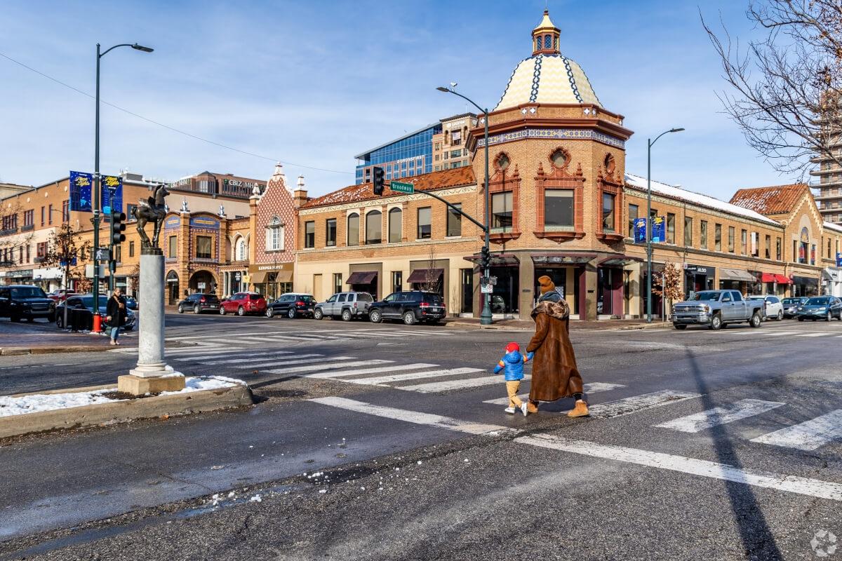 A woman and child cross the street at Country Club Plaza.