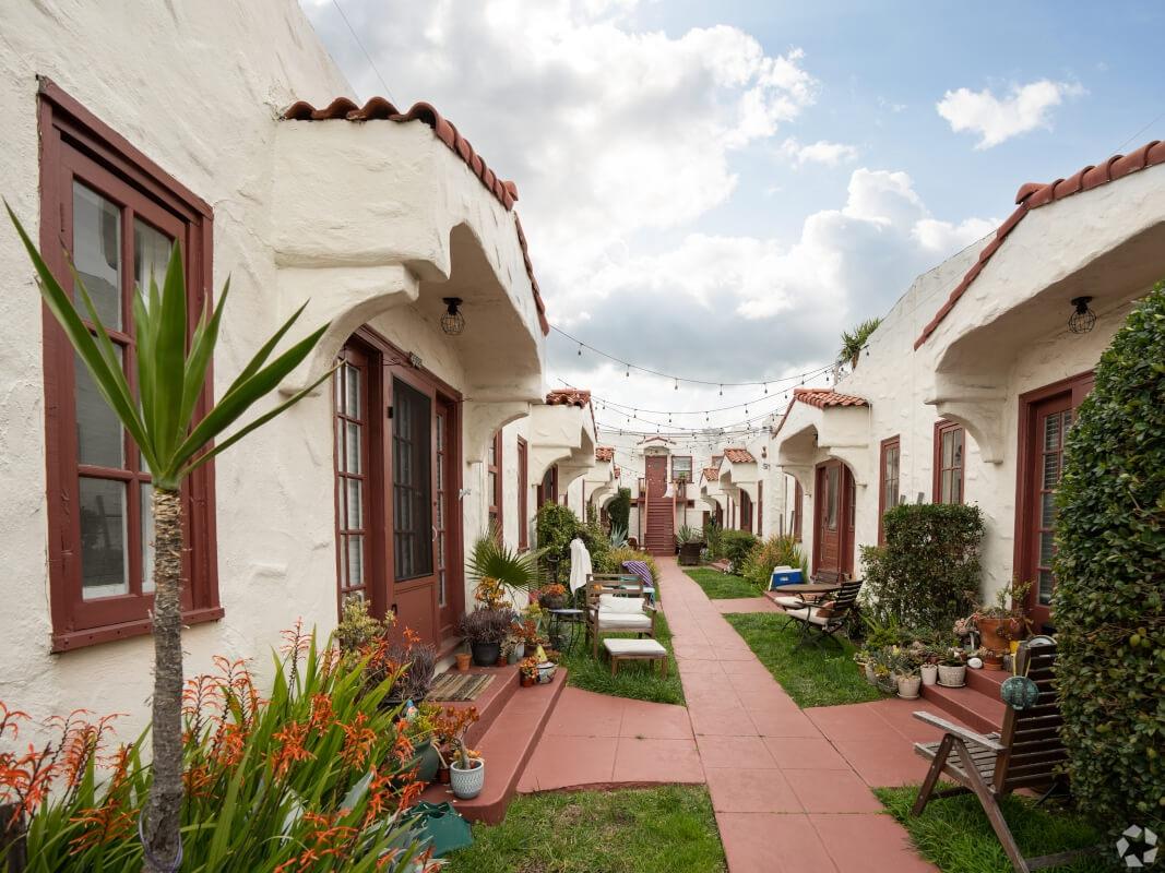 Uniform apartments on left and right with a paved walkway.