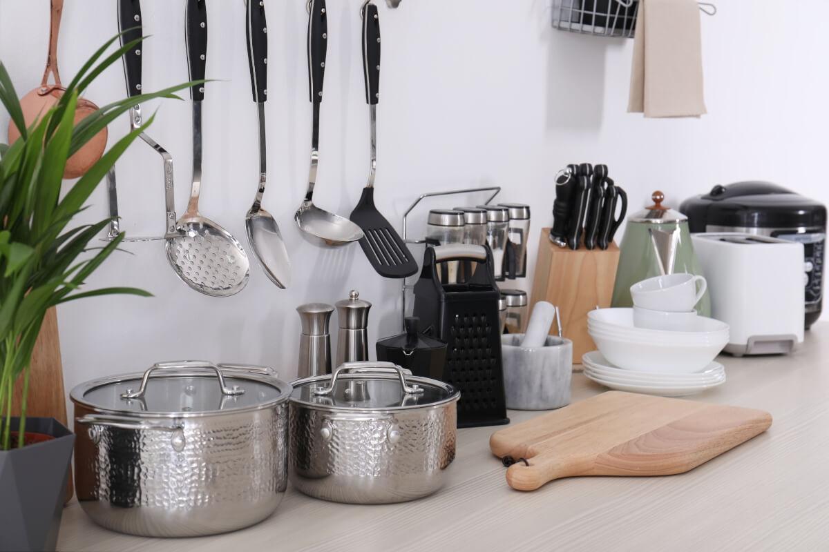 Cookware, dishware, and other kitchen necessities sit on a kitchen counter.