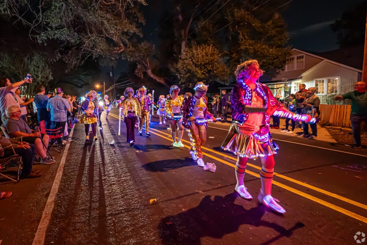 A parade of people in light-up costumes passes by residents in Baton Rouge.