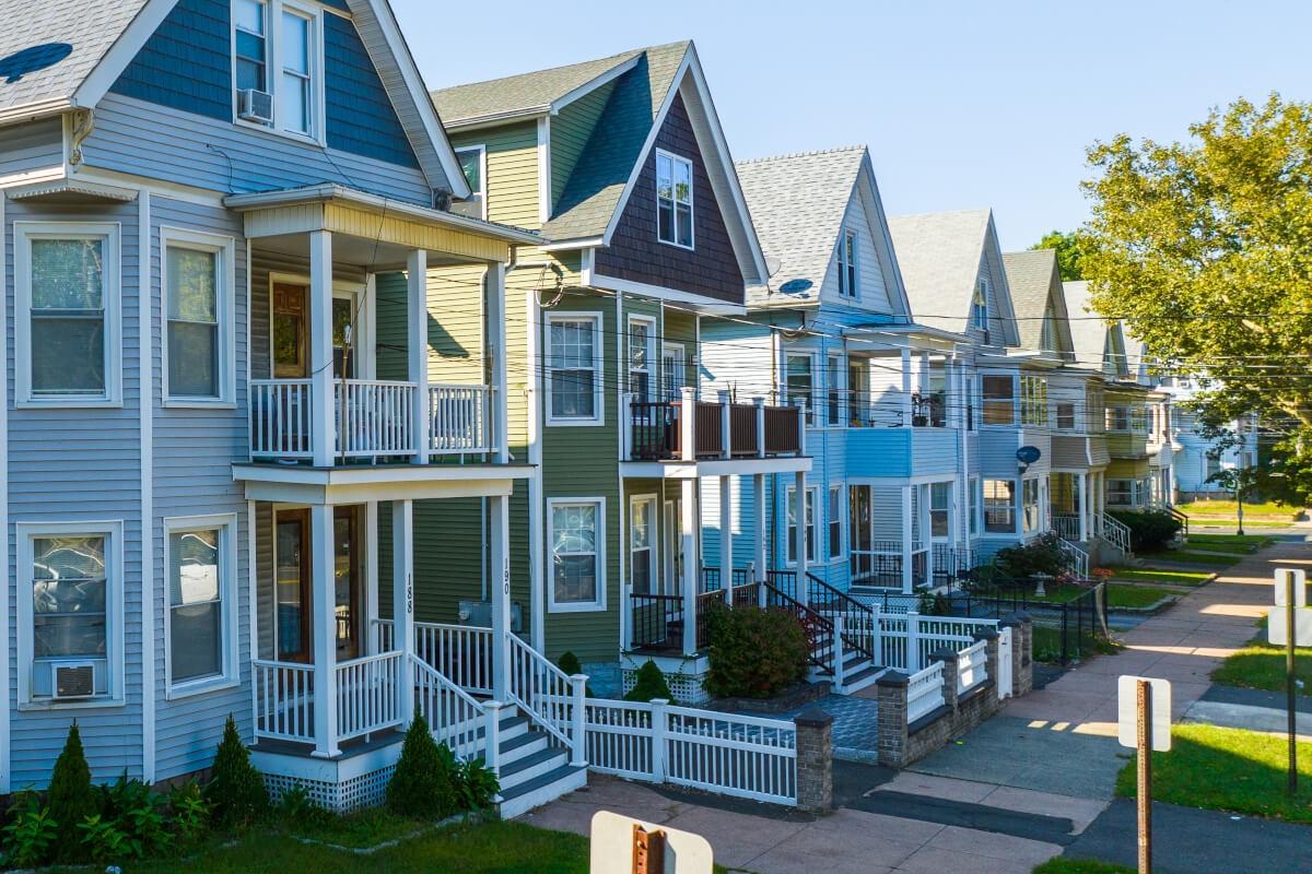 Row houses sit along a residential street in New Haven.