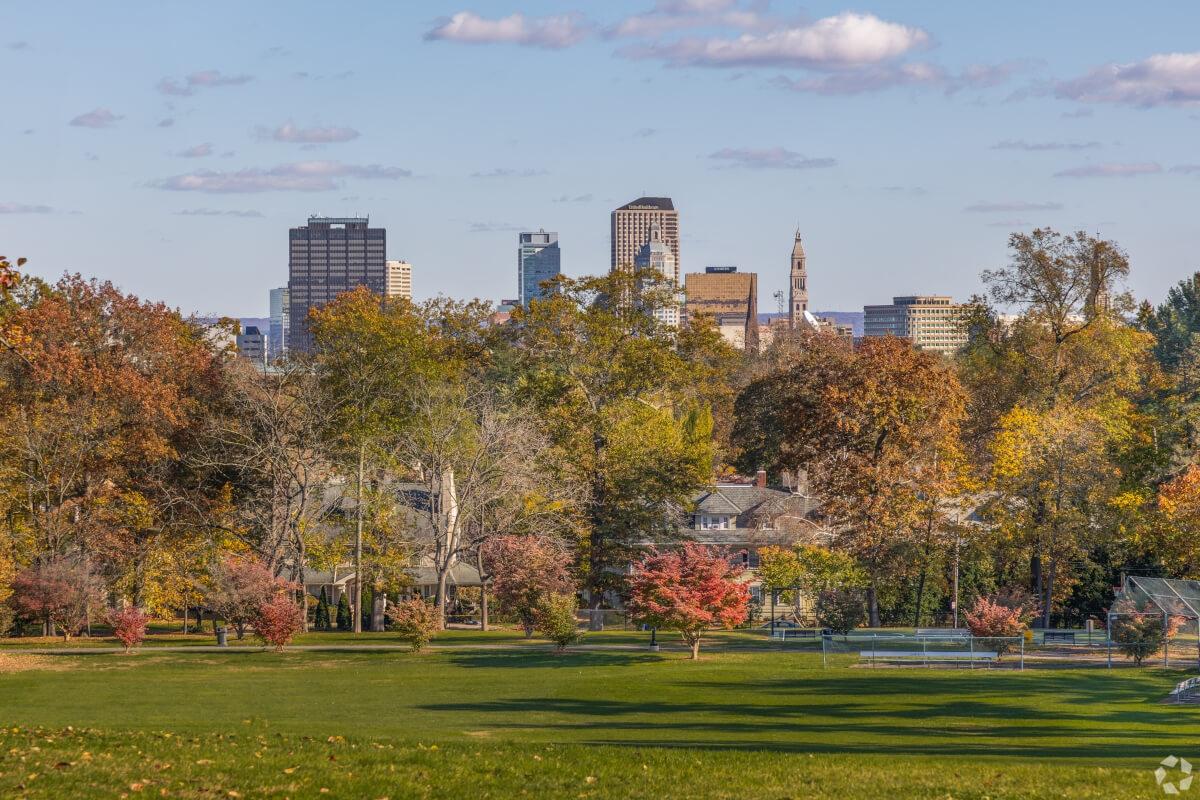 Skyscrapers peek out behind fall foliage at Elizabeth Park in West Hartford.