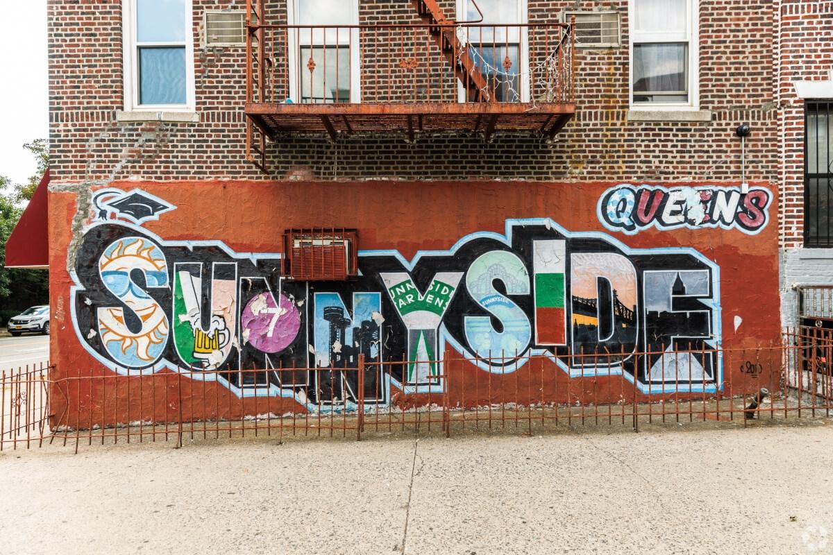 A Sunnyside mural on the side of a red brick building.