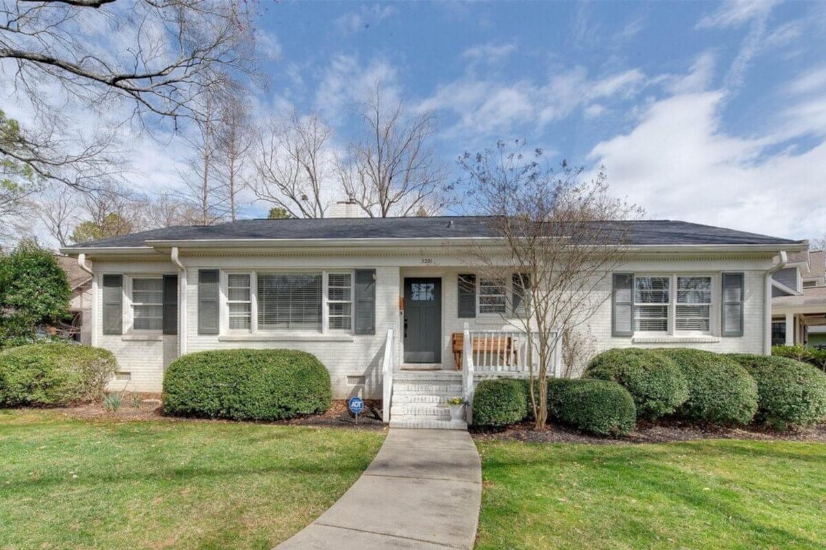 3221 Sunset Drive is a white brick ranch-style house with hedges in the front yard.