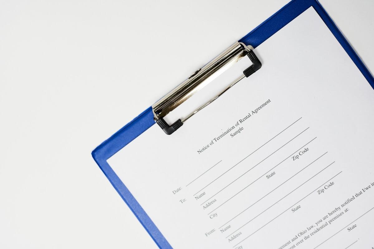 A Notice of Termination of Rental Agreement on a blue clipboard.