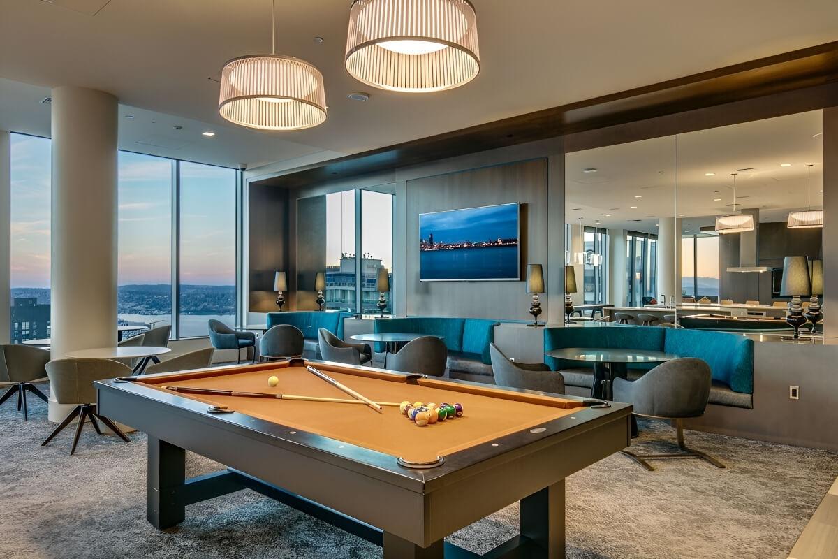 A pool table is in front of booth seating in a rooftop lounge.