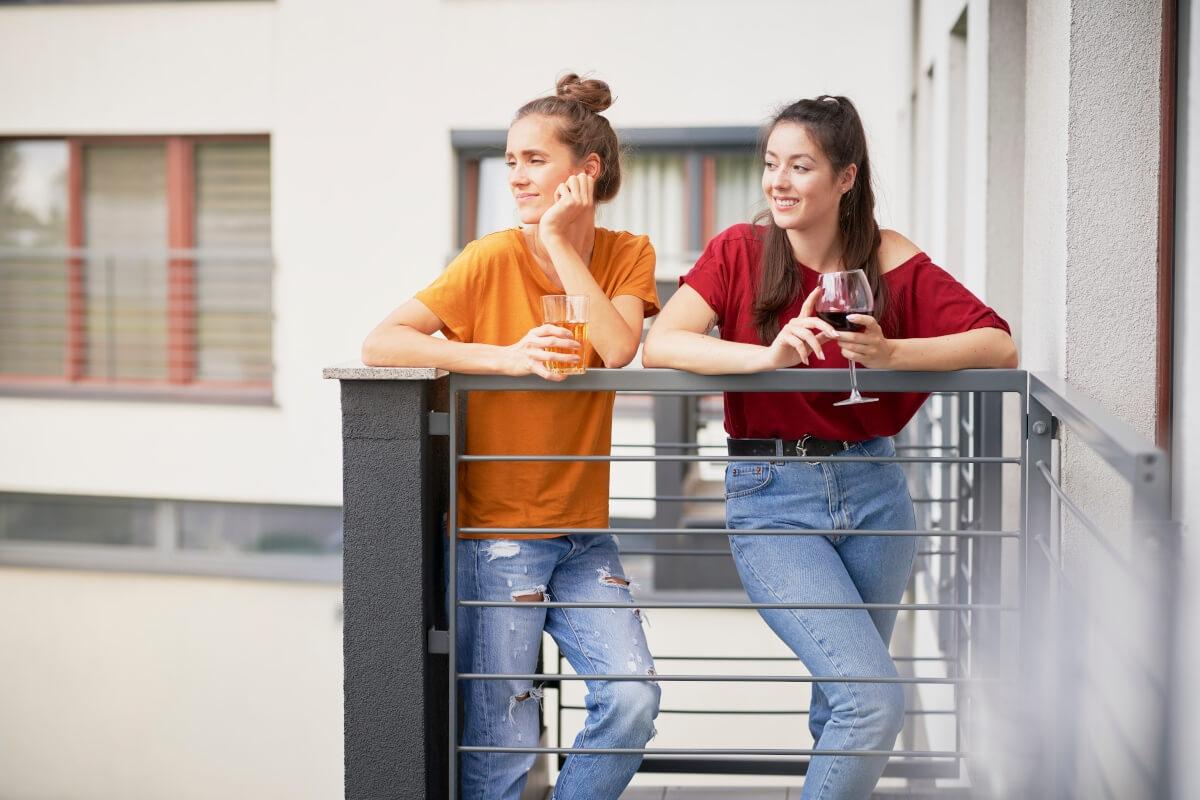 Apartment residents socialize on a balcony.