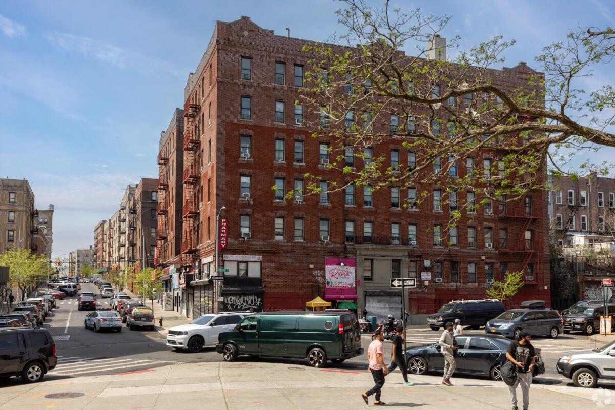 Apartment building in NYC as people walk in front of it.