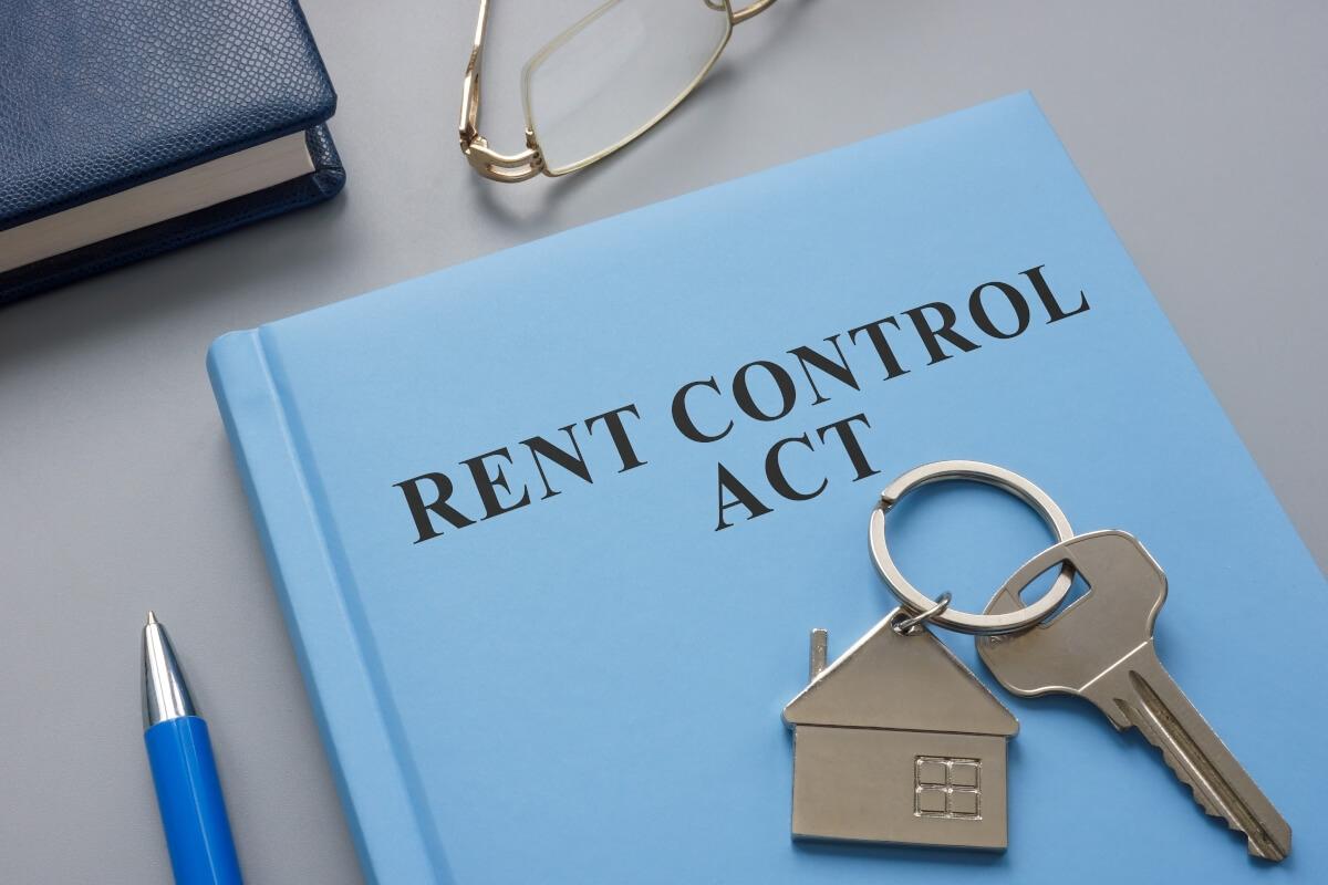 Folder that says "rent control act" with a house key on top.