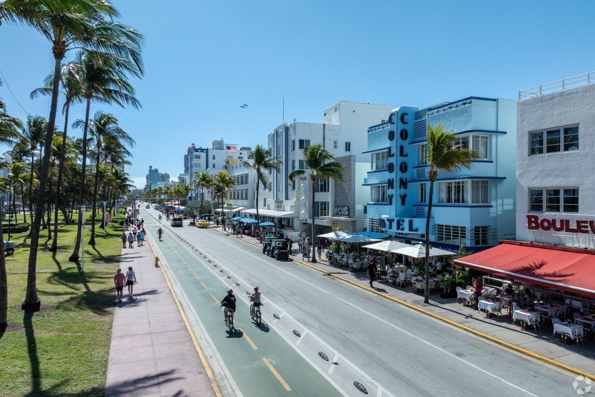 Scenic view of Ocean Drive in Miami Beach with palm trees, art deco buildings, and active pedestrian paths — perfect for exploring local apartments near South Beach nightlife.