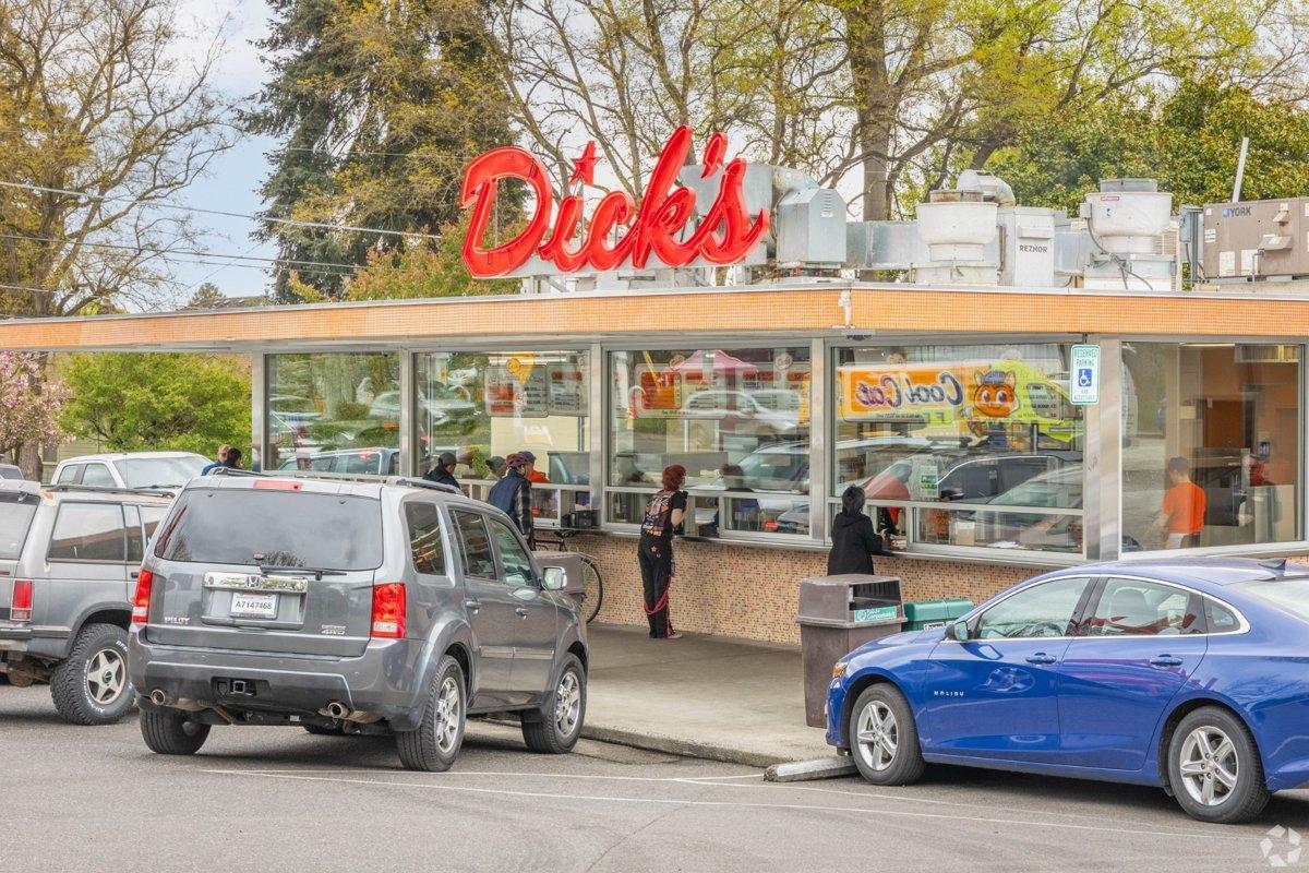 Classic Dick’s Drive-In fast food restaurant in Wallingford Seattle, with retro signage, parked cars, and customers at the walk-up window