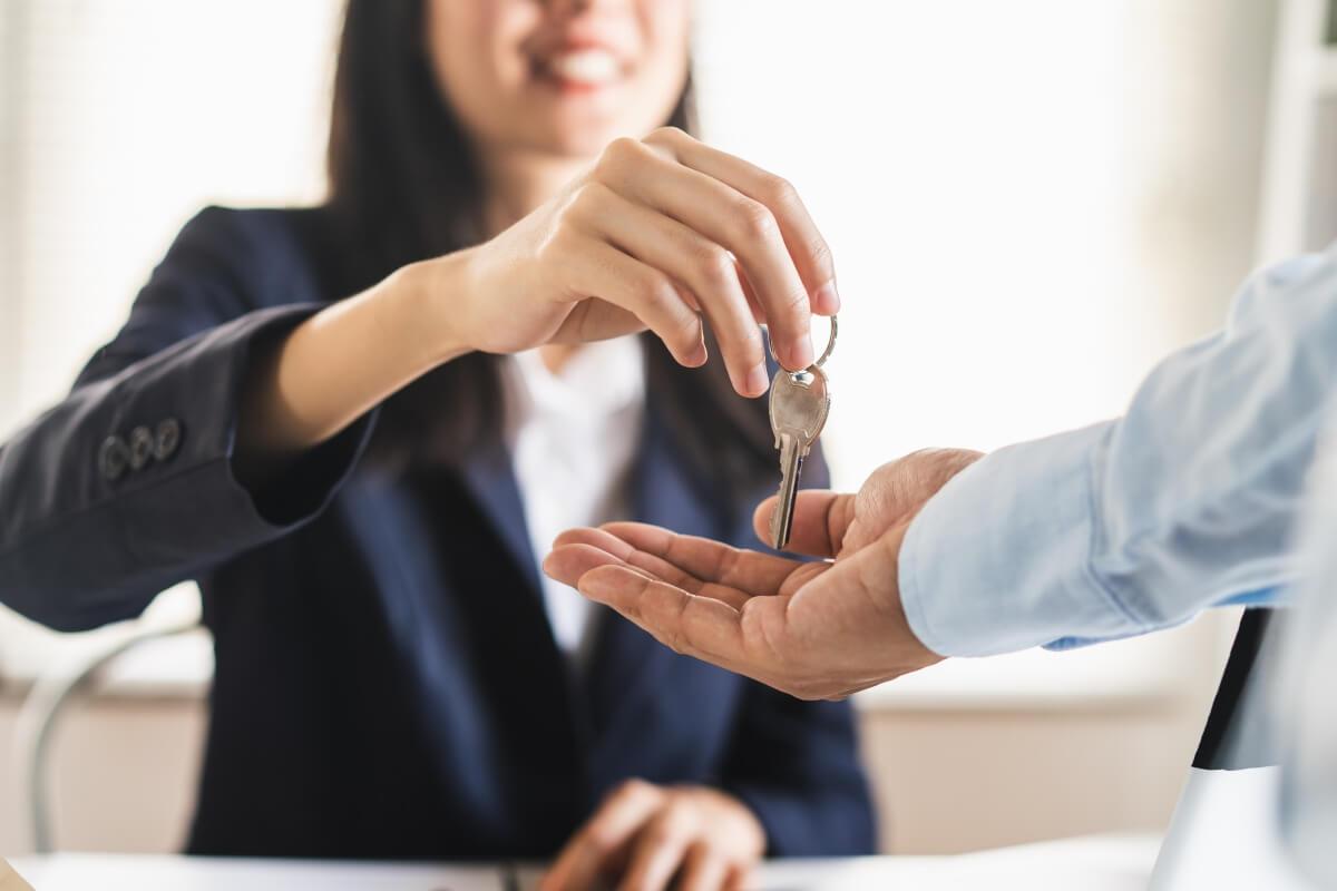 Landlord hands tenant house keys.
