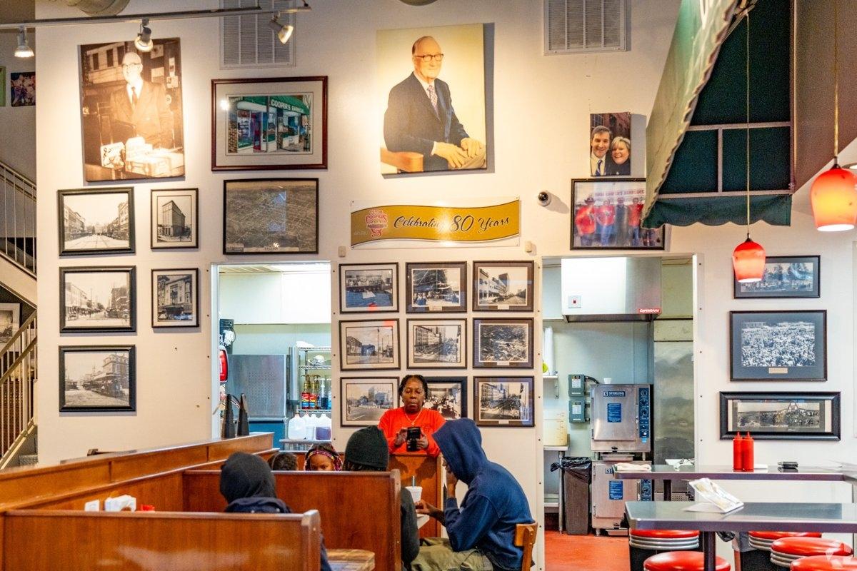 Interior of Clyde Cooper’s BBQ in Raleigh NC showing historic photos and diners enjoying Southern barbecue.