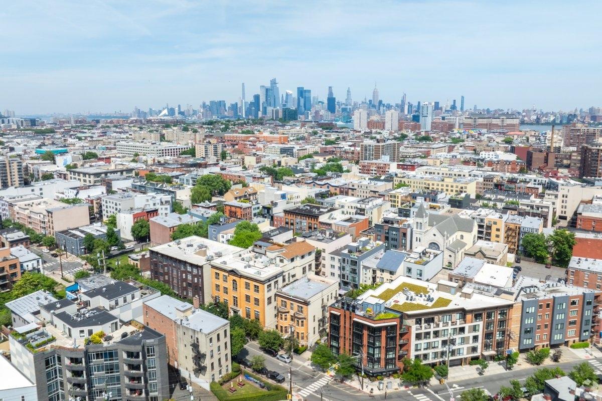 Aerial view of Hoboken neighborhood with Manhattan skyline in the background – central location and quiet charm of Midtown Hoboken.