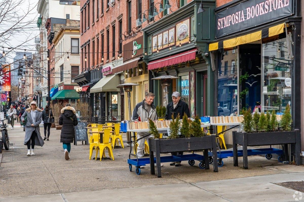 Bustling sidewalk in Hoboken with bookstores, cafes, and pedestrians – student-friendly and vibrant Castle Point area near Stevens Institute.