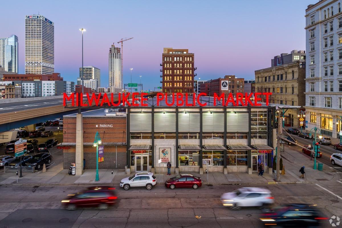Exterior view of the Milwaukee Public Market with downtown high-rises in the background, ideal for urban apartment dwellers exploring local food options.