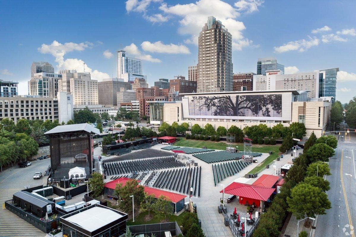 Aerial view of Red Hat Amphitheater and Raleigh skyline with seating and stage layout.