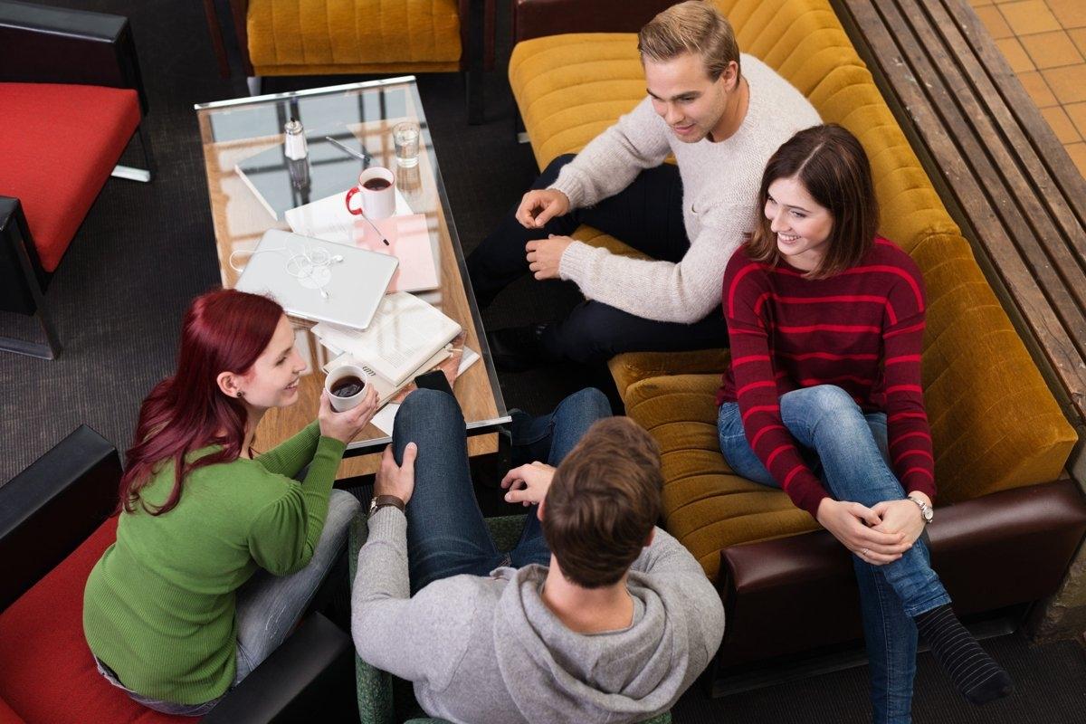 Group of friends gathered in a common area, symbolizing collaborative rent sharing strategies based on individual income levels.